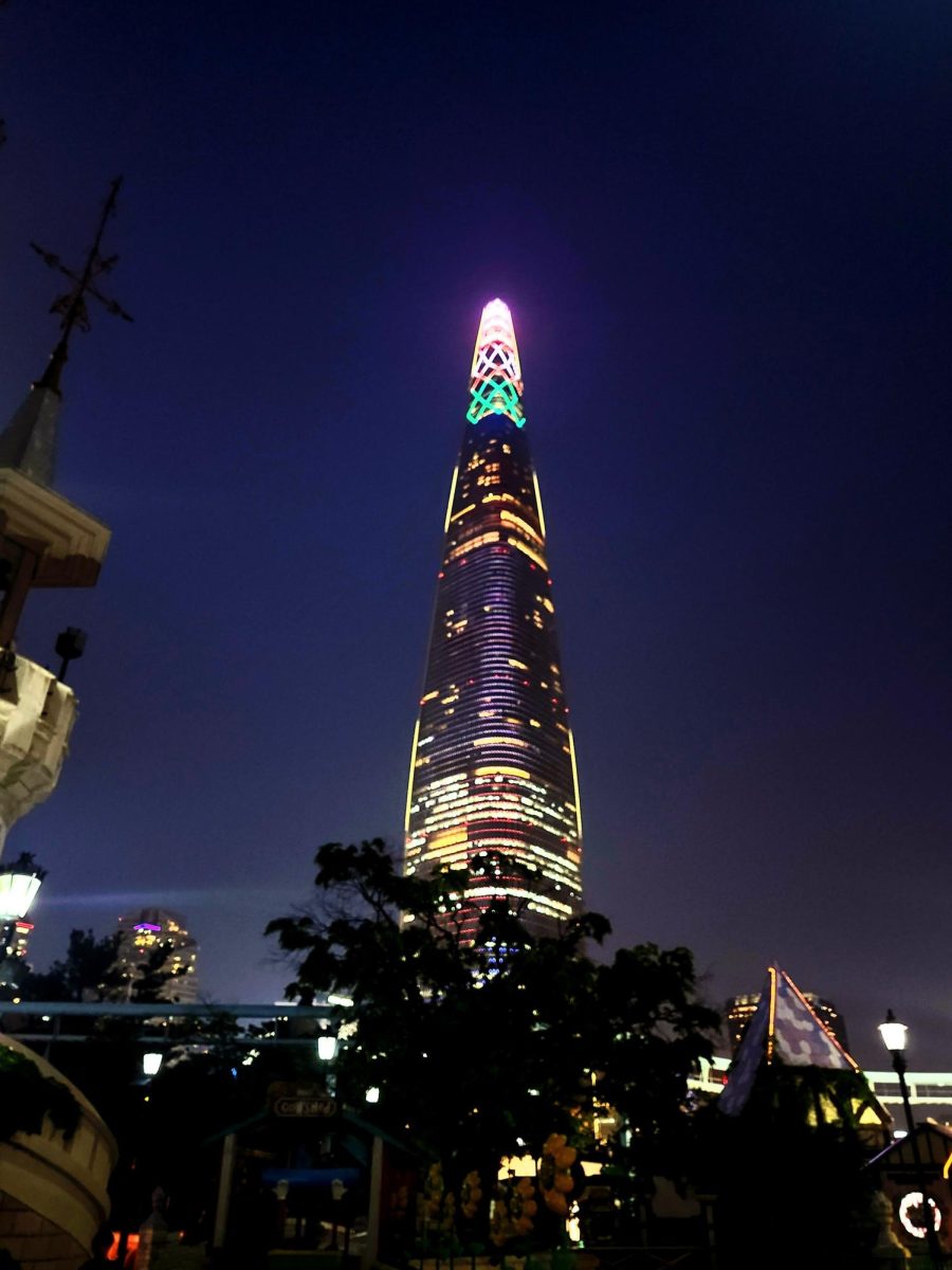 The Seoul Sky Tower, seen from ground level, lit up in the evening.